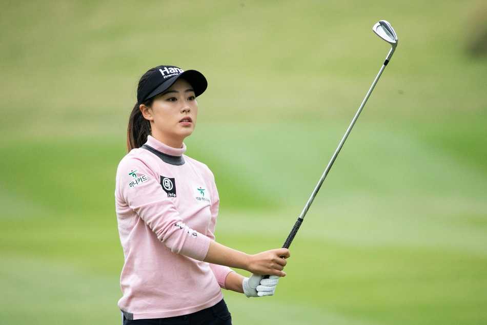 隋响侧身凝视球道，阳光洒在她的球帽上，形成一道专注的剪影