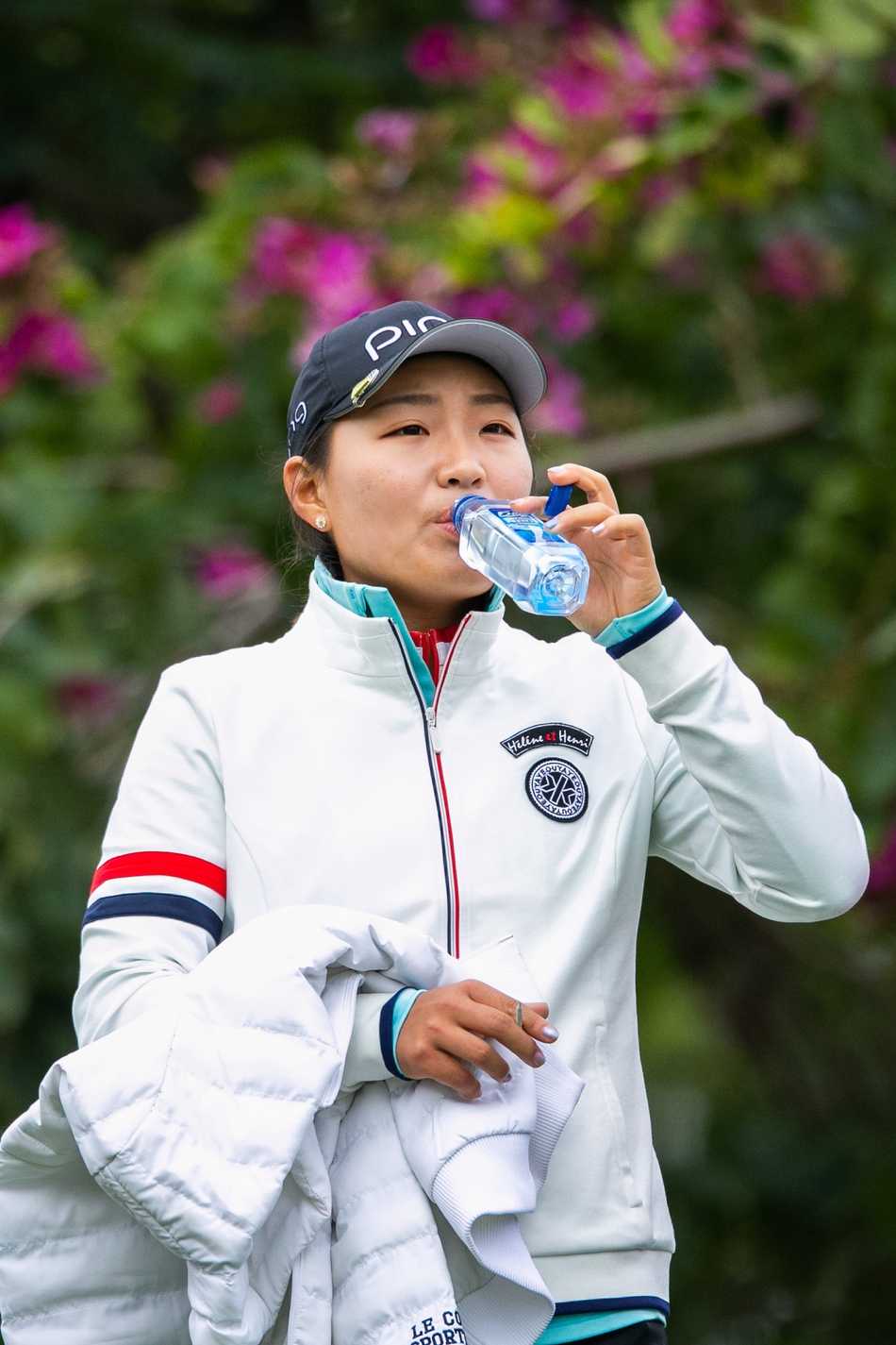 年轻球手李旻在果岭边弯腰仔细观察草纹走向，眼神锐利如鹰