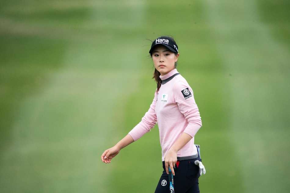 冯珊珊与同组球员在球道上并肩前行，身影在辽阔的球场中显得坚定而从容