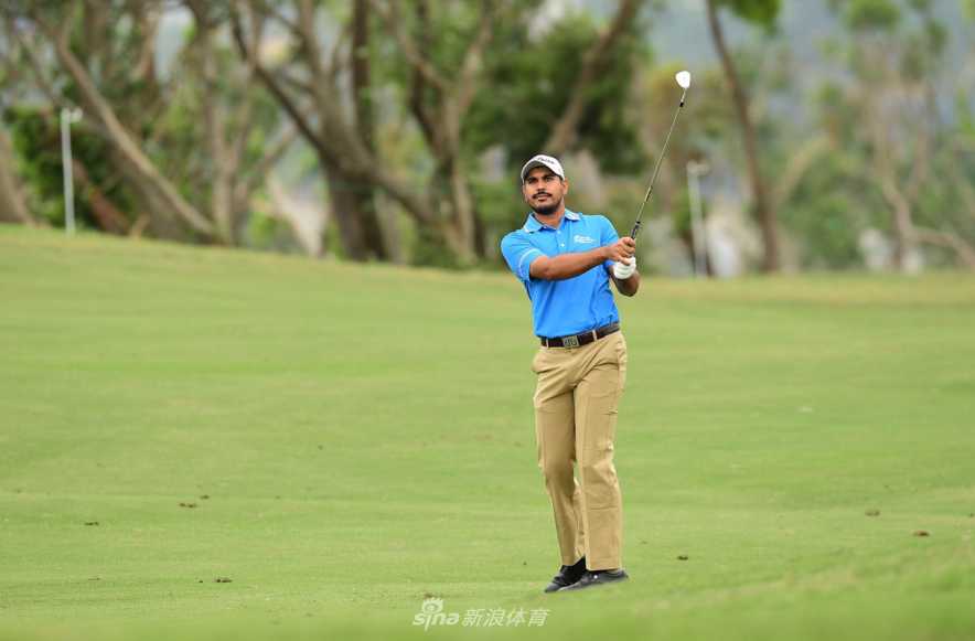 印度名将刚杰布拉全力挥杆，动作充满力量感，背景是浓密的绿荫