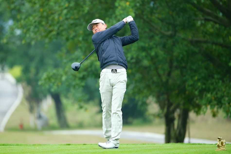 黄文义拉紧衣领抵御寒风，目光坚毅望向远方球道