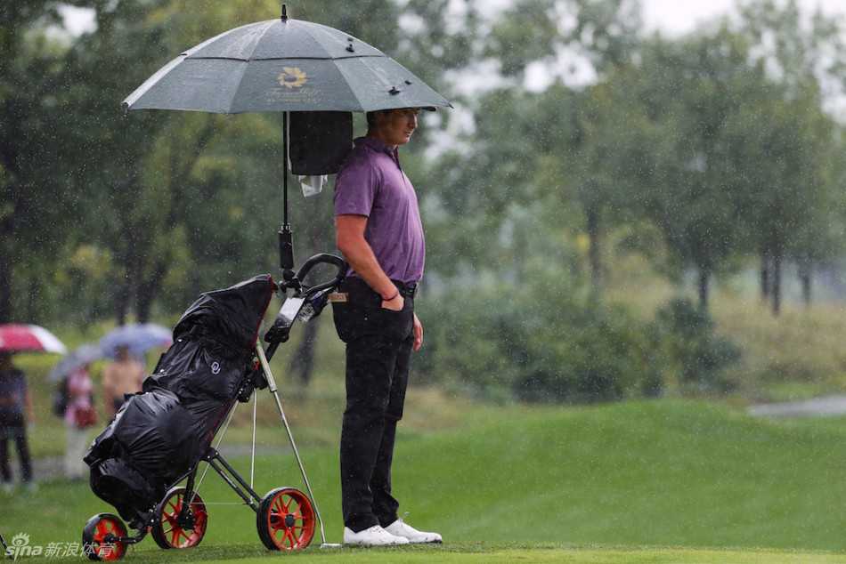 查利-萨克森在果岭上沉稳观察推杆线路，冷静谋划制胜一击