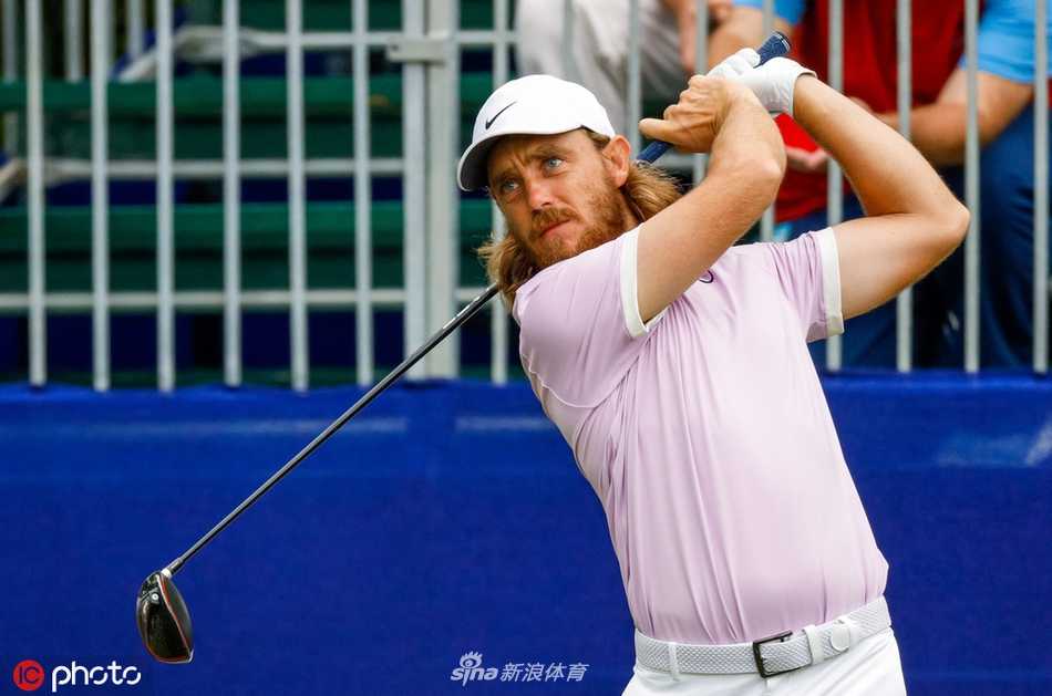 暴雨突袭TPC路易斯安那球场，一位工作人员正冒雨紧急覆盖果岭，背景中阴云密布的天空预示比赛将被迫长时间中断