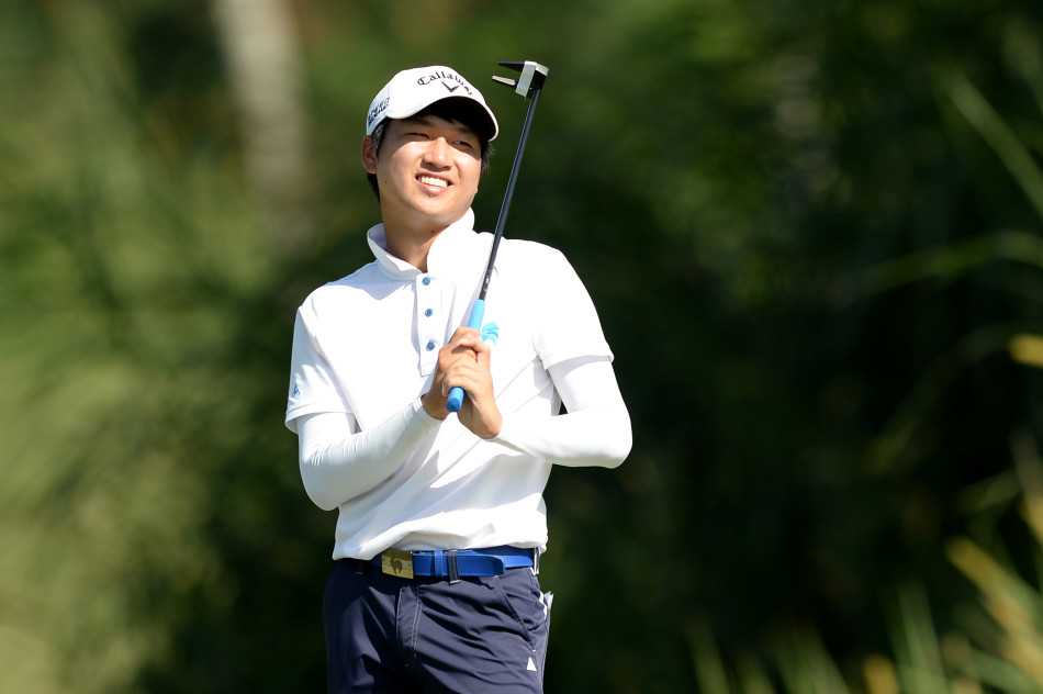 赛场观众聚集在果岭周围，屏息凝神地观看球员决定胜负的推杆一击