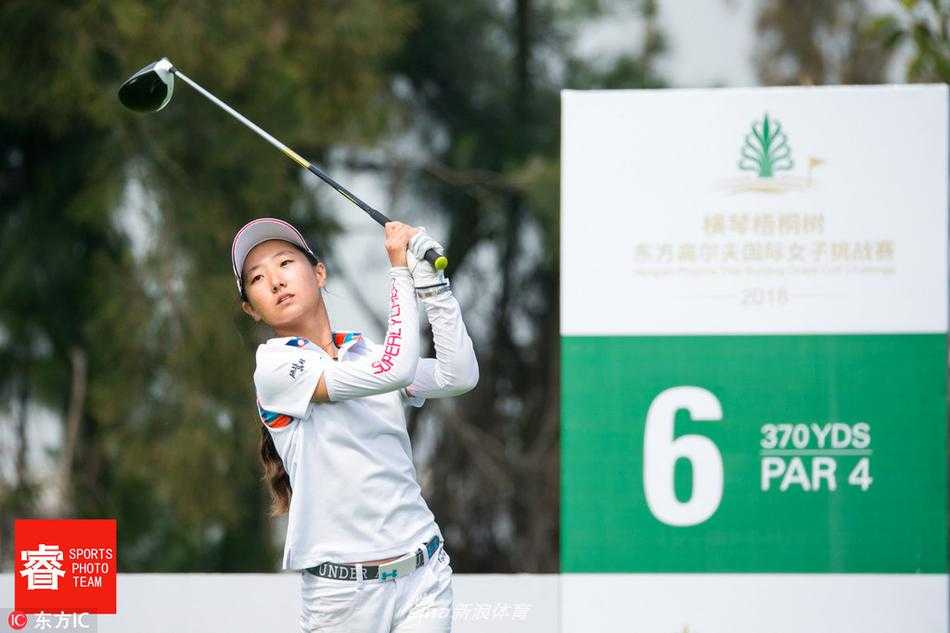 两位球员在球道上并肩前行讨论策略，阳光将她们的影子投射在绿茵之上