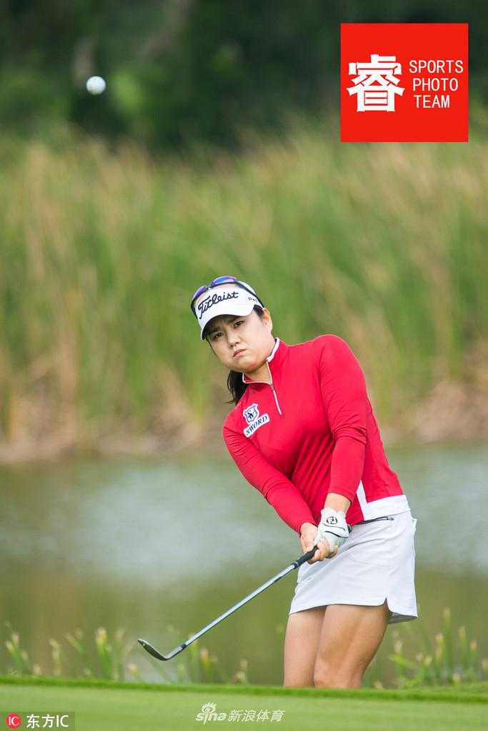 冠军球手高举奖杯瞬间绽放灿烂笑容，身后的棕榈树与蓝天共同为她加冕