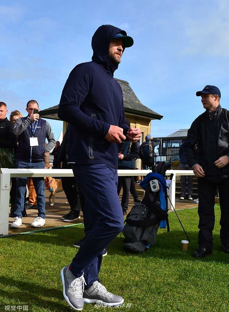 汀布莱克侧身站立，正在调整握杆姿势，表情认真专注，展现其对待高尔夫运动的严谨态度。