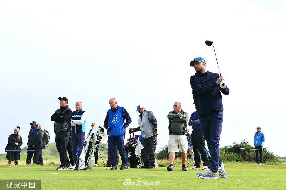 夕阳余晖下，贾老板与罗斯漫步在练习果岭，背影拉长，气氛和谐，仿佛在复盘一天的训练收获。