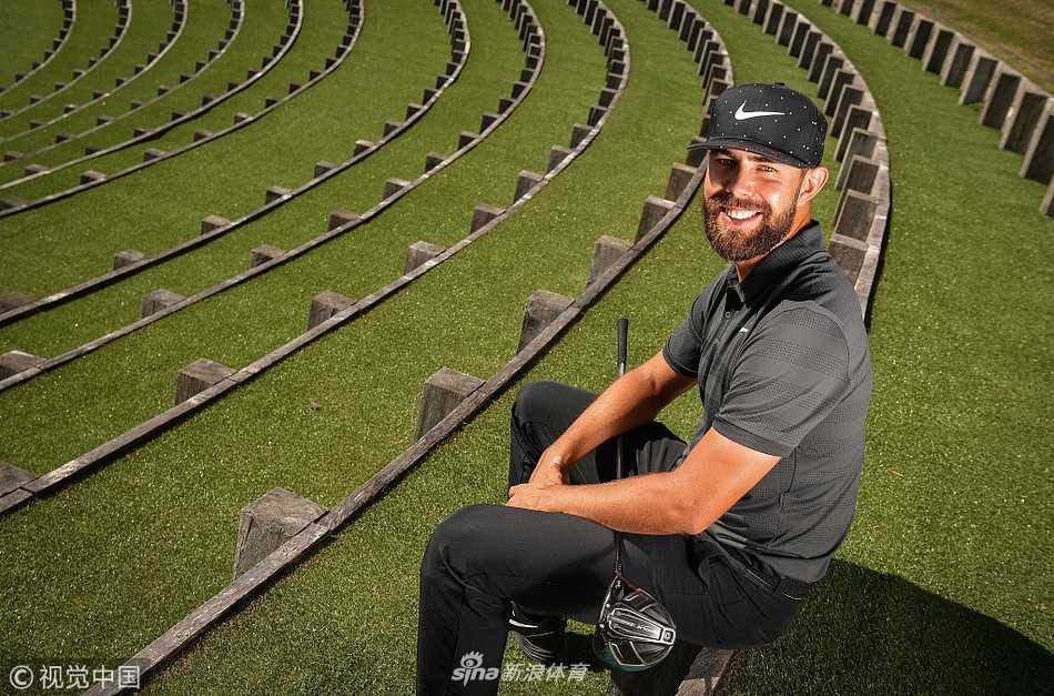 高尔夫名将凝神注视小白球，身后是层峦叠嶂的阿尔卑斯山脉，专注神情与自然背景形成动静对比