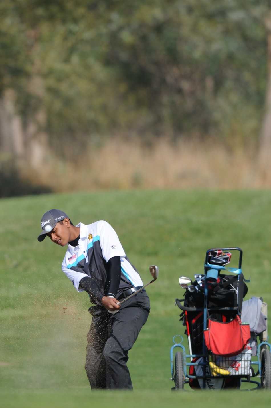 澳大利亚球员乔·查尔顿向空中抛洒草屑，认真判断风力和风向，为关键一击做足准备。