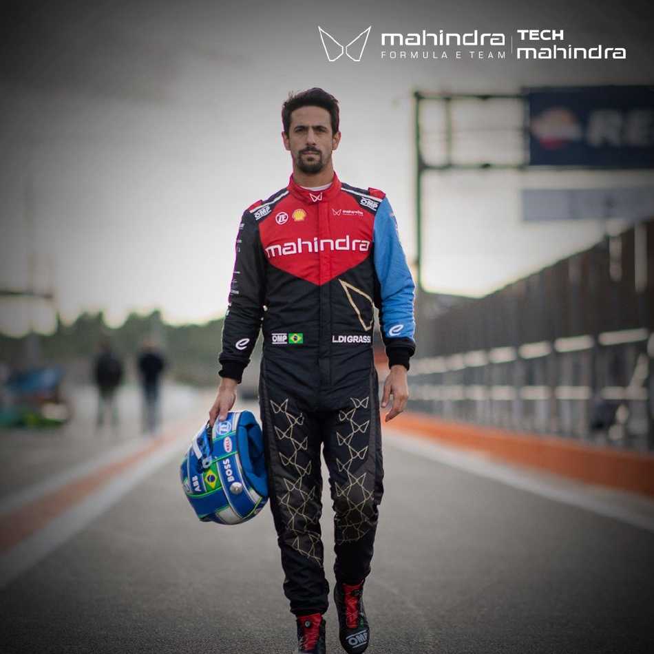 技术人员手持精密仪器俯身检测轮胎表面，指尖轻触橡胶颗粒，每一个细节都关乎稍后赛车在极限状态下的抓地力表现。