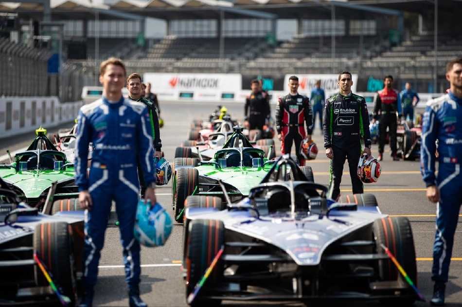 全景俯瞰，数台色彩各异的赛车如宝石般散落在蜿蜒的灰色赛道上，构成一幅充满现代科技美感的动态画卷。