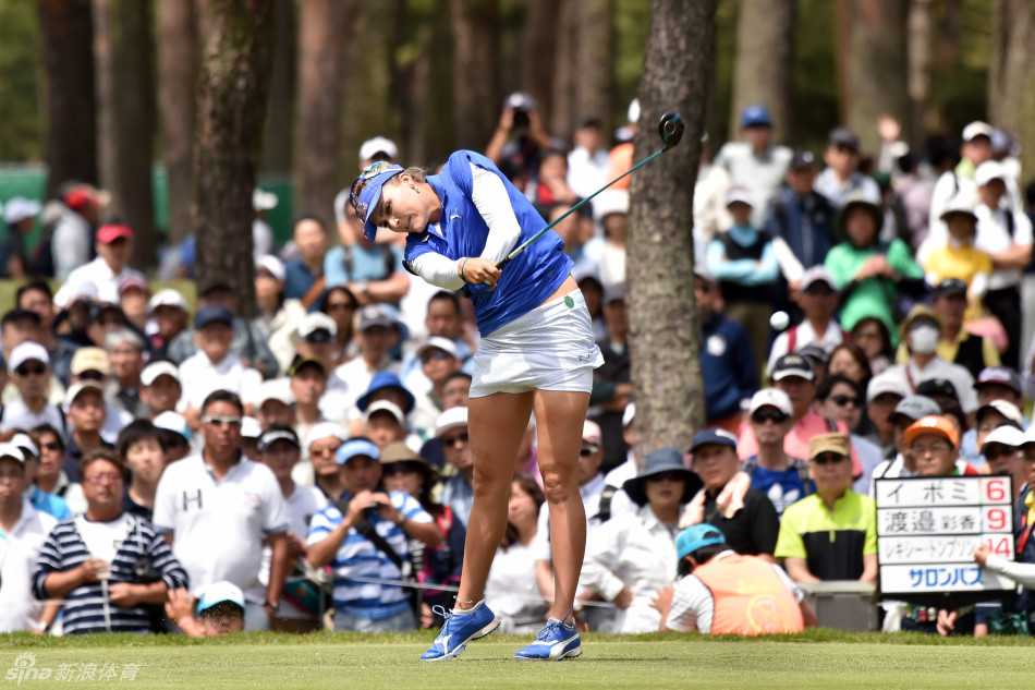 渡边彩香在果岭边凝神审视切杆线路，神情专注，展现出顶尖球员的严谨与拼搏精神。