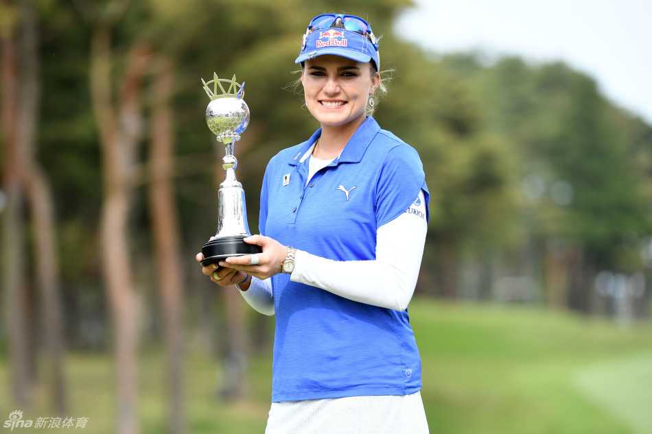 莱克西·汤普森手捧冠军奖杯，向周围热情鼓掌的日本球迷挥手致意，眼中充满感激。