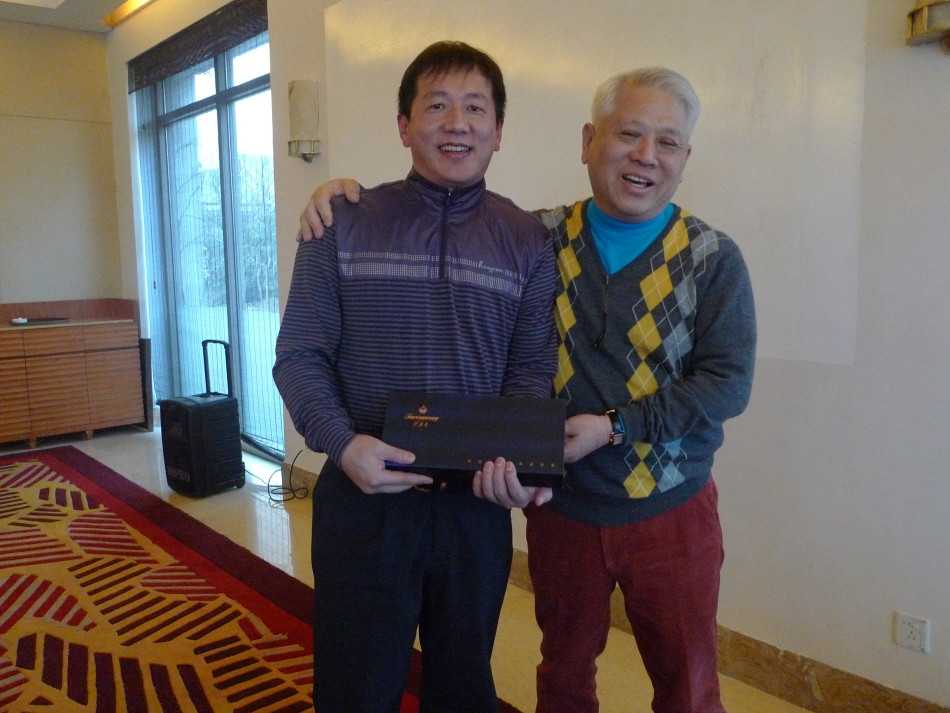 远处球手正在推杆，近处是摆放整齐的“百鸟争鸣”礼品，构成一幅运动与礼赠相结合的完整画面