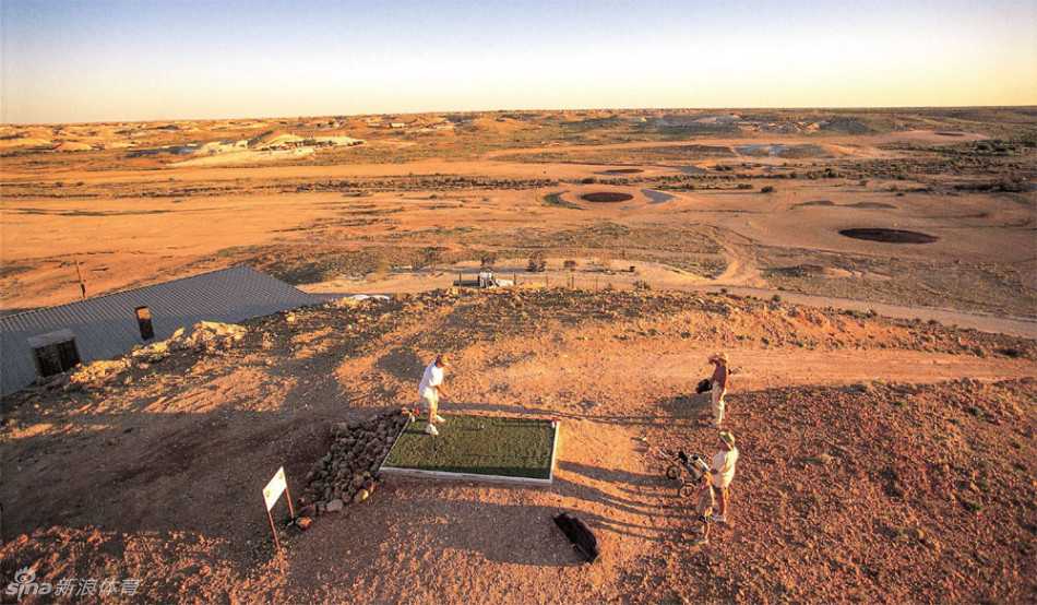 从空中俯瞰，球场果岭如同点缀在红色荒漠中的黑色圆盘，与远处星罗棋布的欧泊矿堆形成奇异的呼应。