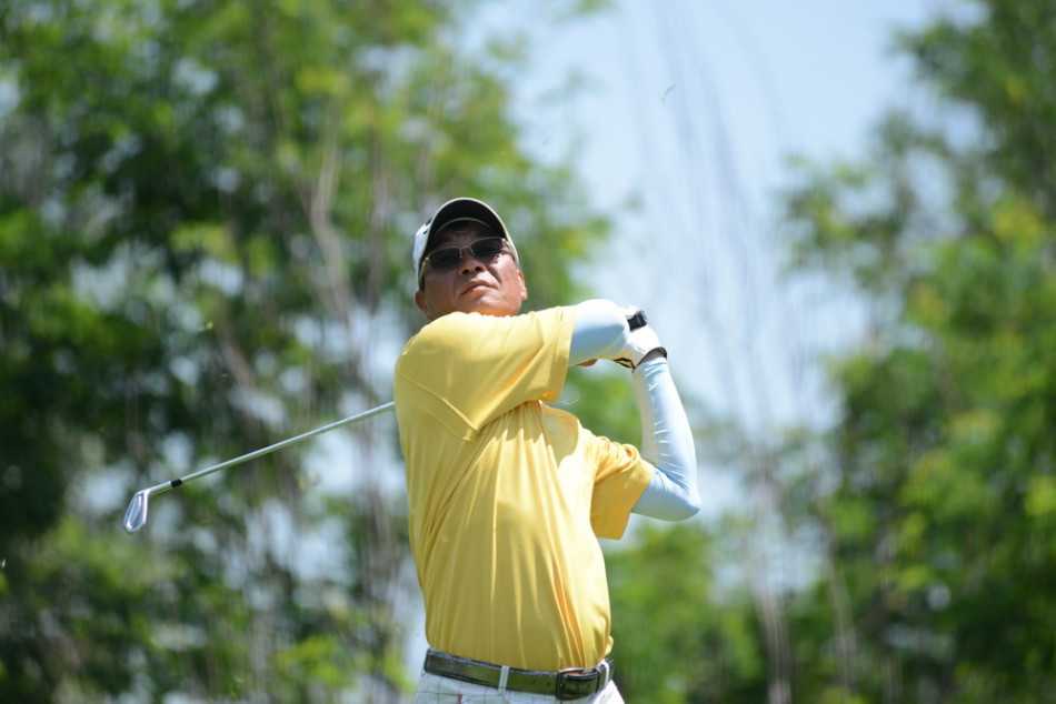 球手在果岭边沙坑中全神贯注救球，沙粒飞扬瞬间展现出高超的短杆技巧